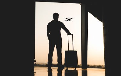 silhouette of man holding luggage inside airport